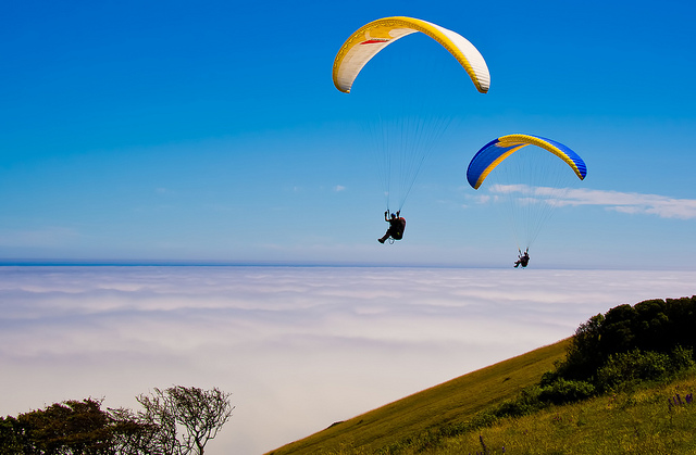 Image of two people hang gliding over the coast.