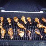 Image of grilled chicken legs on an outdoor grill.