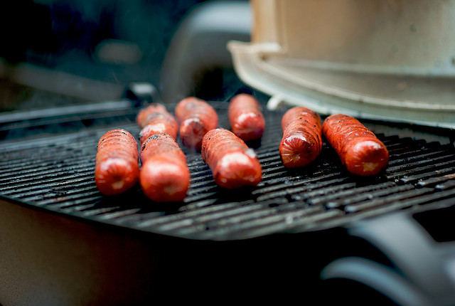 Image of 8 hot dogs on a grill.